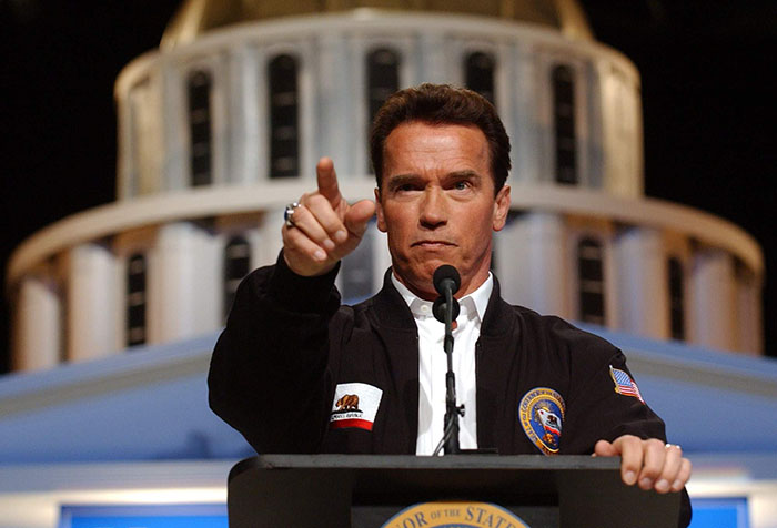Gov. Arnold Schwarzenegger points to a reporter while taking questions during a news conference at Cal Expo in Sacramento, Calif., Wednesday, Feb. 23, 2005. Standing in front of a mock-up of the state Capitol, Schwarzenegger called on lawmakers to approve a constitutional amendment that automatically cuts state spending across the board if spending execeeds state revenues. (AP Photo/Rich Pedroncelli)